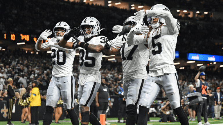 A group of football players celebrating a play in black and white uniforms